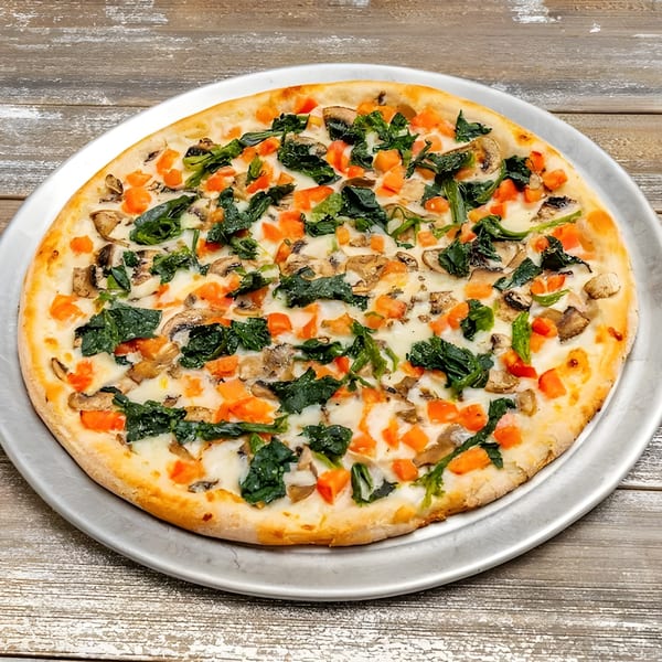Roma Pizza Restaurant's white pizza with spinach, mushrooms, and diced tomatoes on a metal tray.